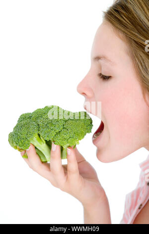 Teenage girl eating broccoli Banque D'Images