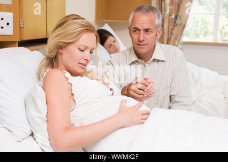 Femme enceinte dans la douleur avec son mari à l'hôpital Banque D'Images