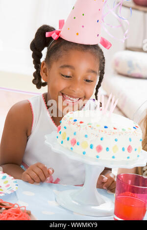 Young Girl wearing party hat à au gâteau smiling Banque D'Images