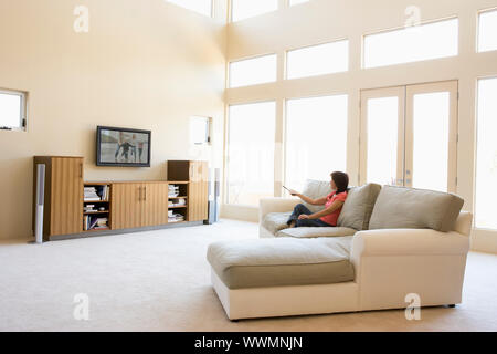 Femme dans le salon à regarder la télévision Banque D'Images