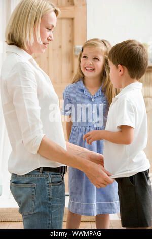 Femme en face couloir avec deux jeunes enfants sourire Banque D'Images