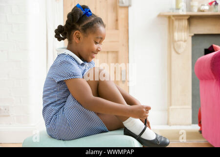 Jeune fille à l'avant de la chaussure et fixation couloir smiling Banque D'Images