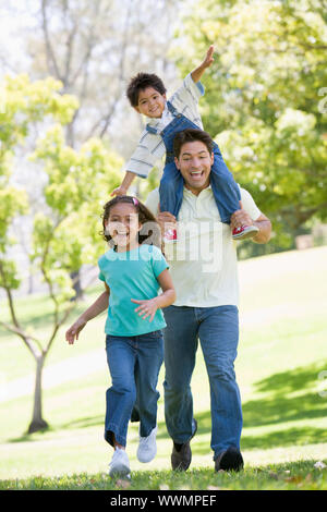 Homme avec deux jeunes enfants exécutant outdoors smiling Banque D'Images