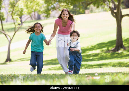 Femme avec deux jeunes enfants exécutant outdoors smiling Banque D'Images