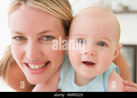 Mère en salon avec baby smiling Banque D'Images