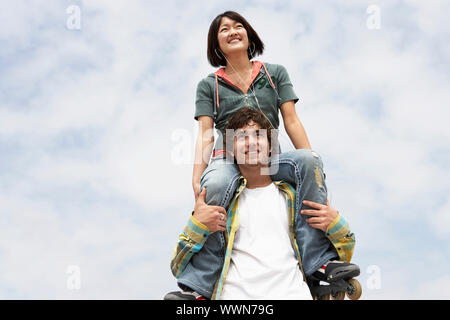 Jeune homme avec femme sur les épaules Banque D'Images