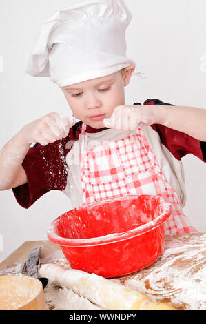 Boy in chef hat pétrir la pâte Banque D'Images