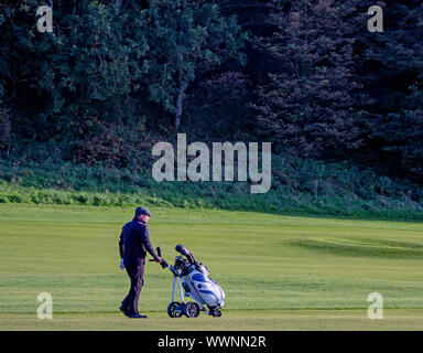 Un golfeur marche avec chariot de golf sur le parcours de golf Glen, North Berwick, East Lothian, Scotland, UK. Banque D'Images