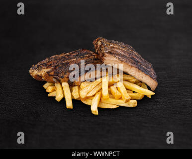 Côtes levées fumées et grillées et frites sur fond noir Banque D'Images