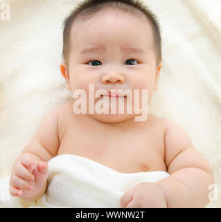 Asian baby boy lying on bed Banque D'Images