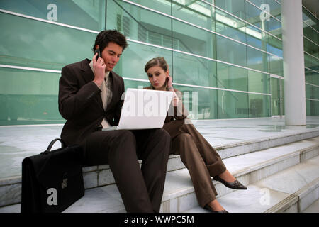 Jeune couple assis sur les marches d'affaires Banque D'Images