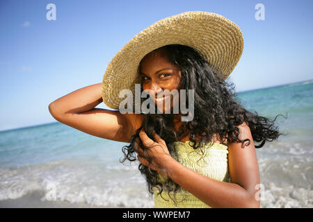 Femme au chapeau de paille ayant was at the beach Banque D'Images