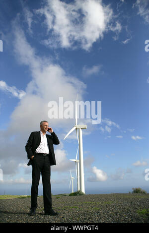 L'homme sur le téléphone à côté d'une éolienne Banque D'Images