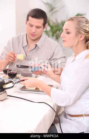 Couple eating raclette Banque D'Images