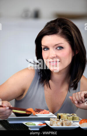 Brunette eating sushi Banque D'Images