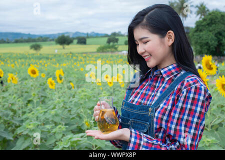 Les jeunes femmes contre la bouteille d'huile de tournesol. Banque D'Images