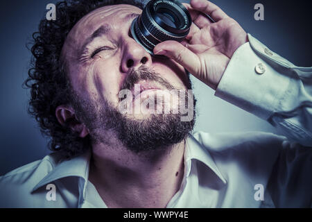 Avec objectif photographe, l'homme avec l'expression intense, chemise blanche Banque D'Images