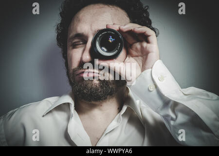 Avec objectif photographe, l'homme avec l'expression intense, chemise blanche Banque D'Images