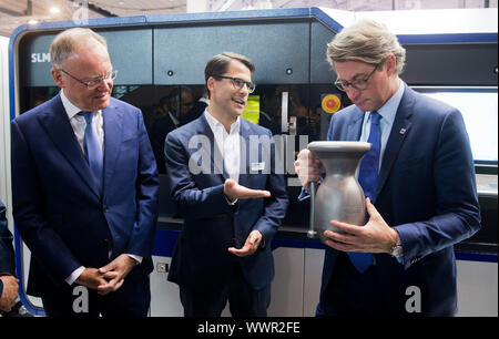 Hanovre, Allemagne. 16 Sep, 2019. David Wilckens (M) à partir de solutions SLM indique Andreas Scheuer (r, CSU), Ministre fédéral des Transports et de l'infrastructure numérique, et Stephan Weil (l, SPD), premier ministre de Basse-Saxe, une fusée à partir d'un composant métallique 3D à l'EMO de l'imprimante de la machine outil. Le spectacle de l'industrie s'étend du 16 au 21 septembre 2019 et est considéré comme le salon leader mondial pour le travail des métaux. Credit : Julian Stratenschulte/dpa/Alamy Live News Banque D'Images