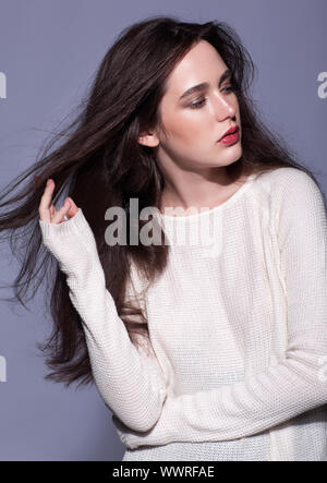 Portrait of de jeune brunette woman portrait en blanc pull femme fashion Banque D'Images