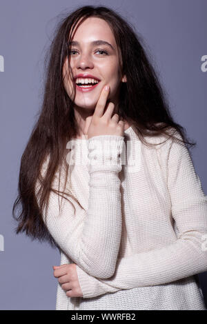 Portrait of happy young brunette woman portrait en blanc pull femme fashion Banque D'Images