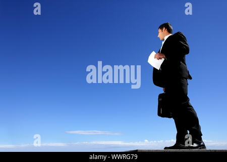 Smart businessman with sky in background Banque D'Images