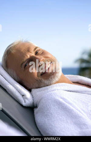 Homme aux cheveux gris sur une chaise longue Banque D'Images