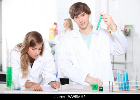 Les étudiants dans une classe avec des tubes à essai et d'autres équipement de laboratoire Banque D'Images