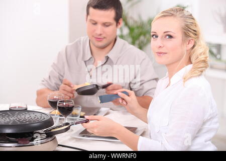 Couple eating raclette Banque D'Images