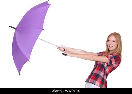 Jeune fille joyeuse avec parapluie contre fond studio Banque D'Images