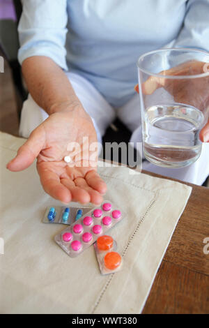 Femme prendre ses médicaments avec un verre d'eau Banque D'Images