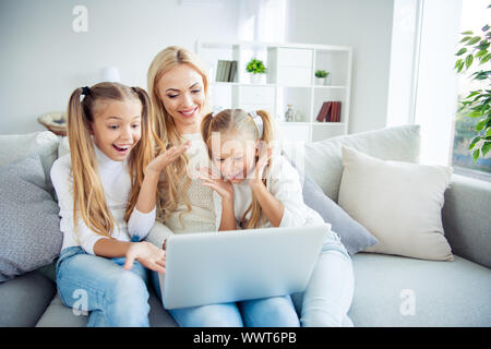 Portrait de trois belle belle belle Gai gai mignon les gens positifs pre-teen girls Maman assise sur le divan faisant appel vidéo w-fi dans Banque D'Images