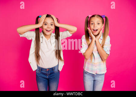 La photo en gros deux petites filles d'âge tête bras mains joues crier crier crier grande loterie fortune boutique shopping mall portant des jeans denim occasionnels Banque D'Images