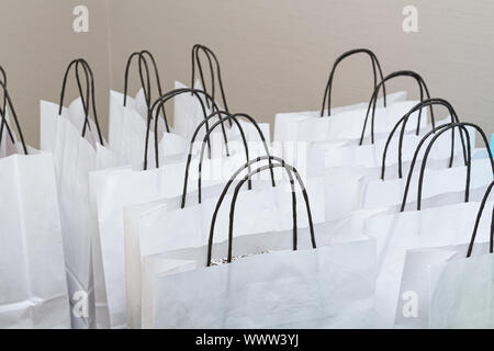 Des sacs de papier blanc avec poignées noires, closeup shot Banque D'Images
