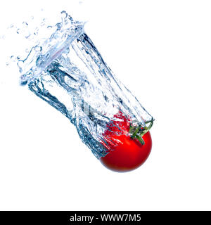 Tomate rouge tombe sous l'eau avec une éclaboussure Banque D'Images