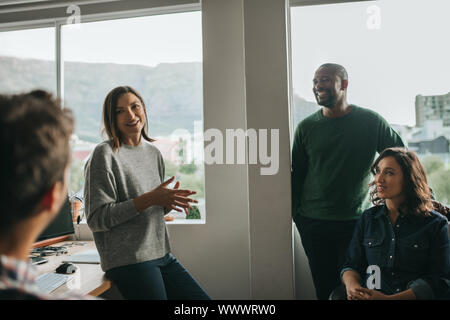 Les concepteurs du projet de discuter d'un sourire lors d'une réunion de bureau Banque D'Images