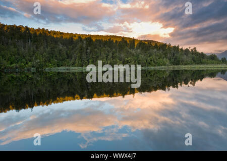 Lever du soleil au-dessus d'un lac sur un matin encore du vent Banque D'Images