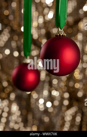 Deux boules de Noël rouge en face d'un gold glitter background Banque D'Images