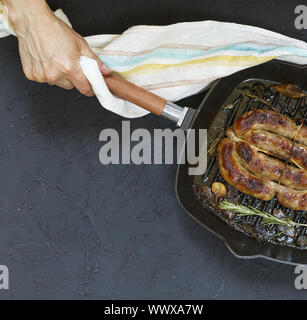 Des saucisses grillées servies par femme en mains Banque D'Images