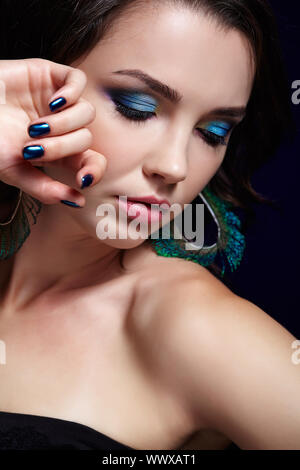Portrait of beautiful brunette woman sur fond noir et plume de paon boucles d Banque D'Images