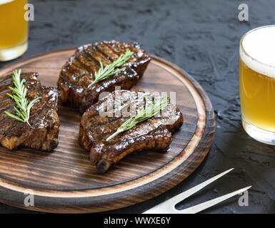 Steaks barbecue appétissant et bière légère Banque D'Images
