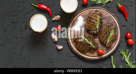 Les steaks appétissants, de bière et de romarin Banque D'Images