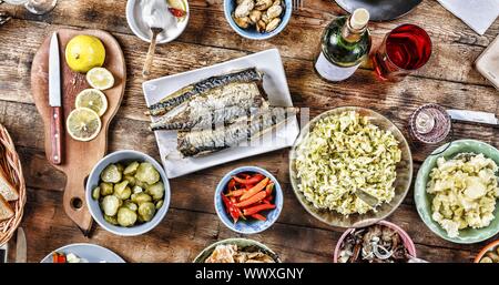 Table de salle à manger avec une variété de collations légères et des salades. Le saumon, olives, vin, légumes, poissons grillés toa Banque D'Images