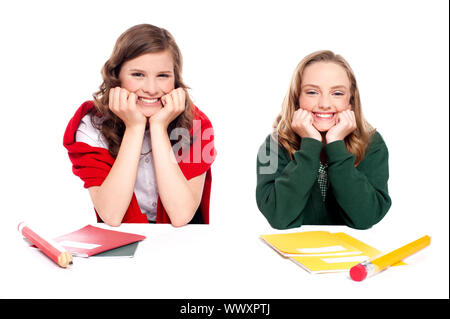 Happy young girls sitting at desk et de repos blindfold isolé sur fond blanc Banque D'Images