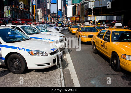 Une vision typique dans les rues si New York City ; une gamme de voitures de police et les taxis, la conduite sur Broadway à Times Square. Banque D'Images