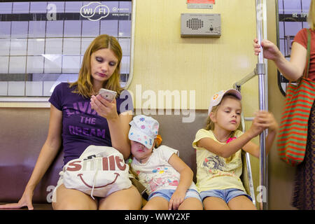 Moscou, Russie - le 10 août 2015 : La situation dans le train du métro de Moscou, la mère se penche sur le téléphone, le plus jeune da Banque D'Images