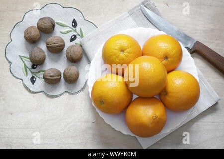 Les oranges sur une plaque et les noix. Banque D'Images