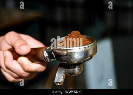 Nous savons qu'un bon café. Café frais moulu. Café au café Tenir en main portafilter Barista. Le café de l'équipement. Barista brews esp Banque D'Images