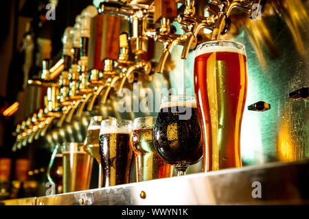 Verres de Dark and Light bière, ale, lager, le stout, le porter dans un style moderne et lumineux neon light avec machine à couler sur l'arrière-plan. Concept de maison de vacances, plaisir, rencontre, l'Oktoberfest, grande partie des amis. Banque D'Images