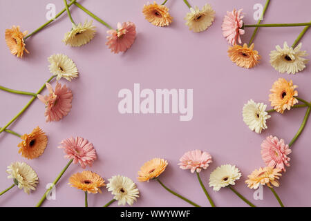 Cadre fait de blanc, rose, orange gerbera sur fond rose. Banque D'Images